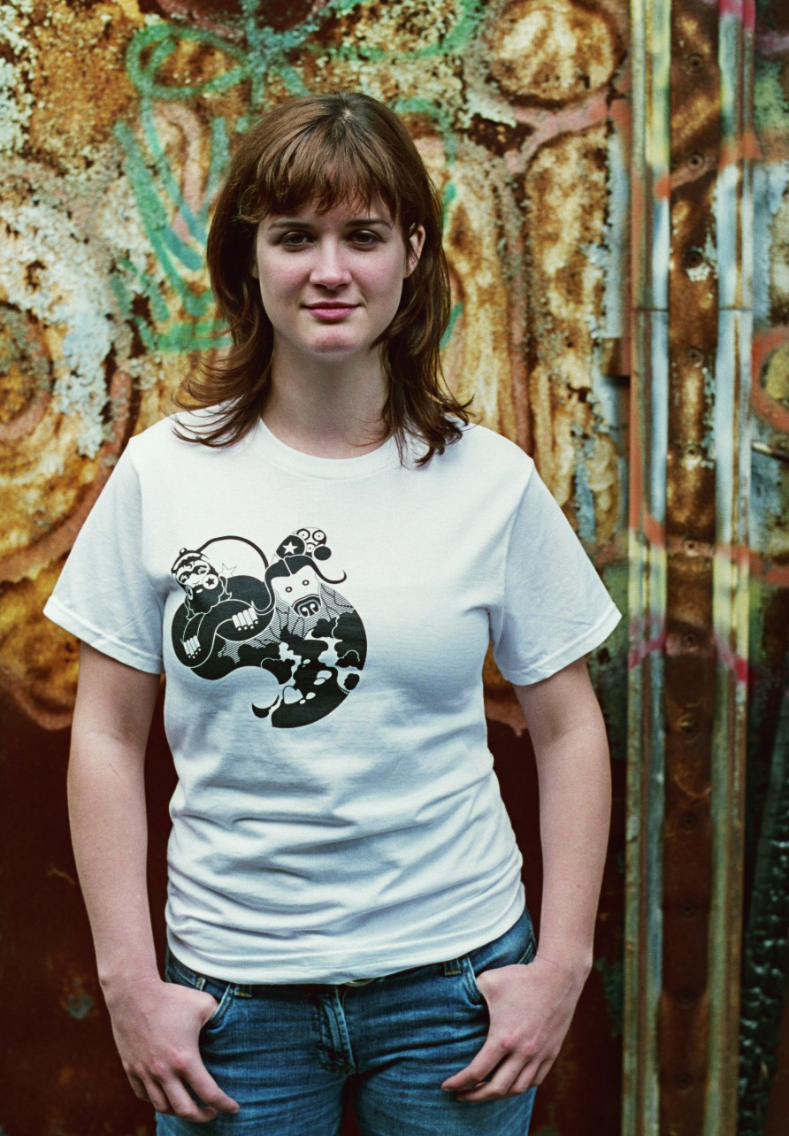 Photograph of a woman modeling a white t-shirt with an abstrtact illustration of a river and Paul Bunyan.