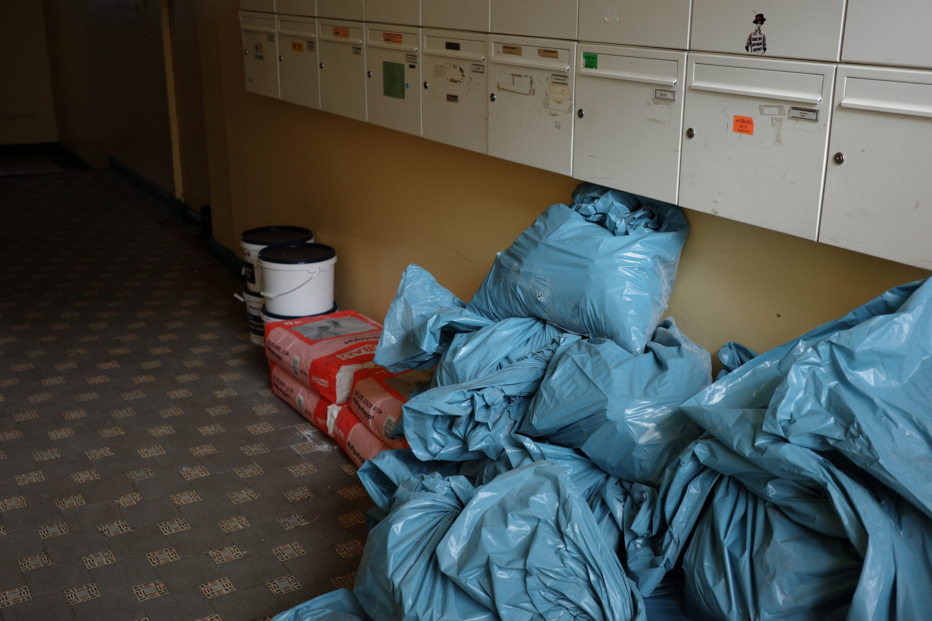 Apartment building hallway with a large pile of construction material.